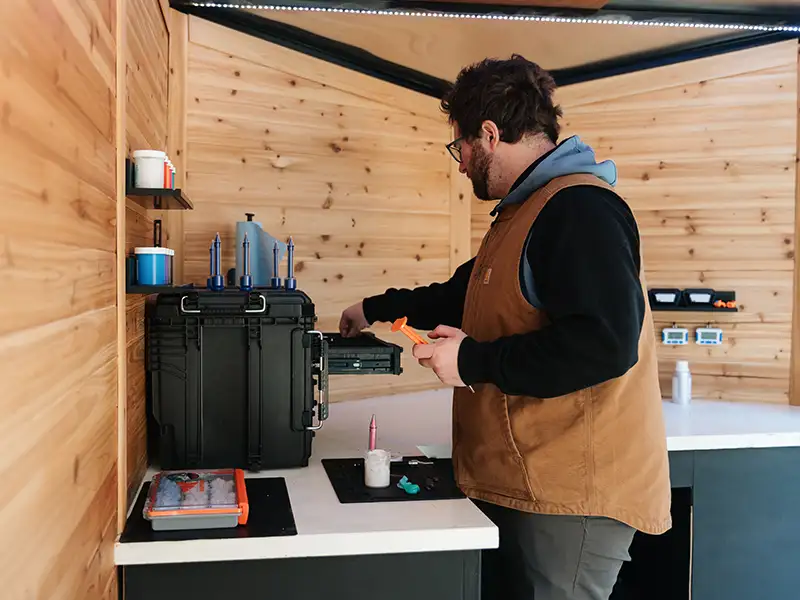 man working on custom hearing mold at counter